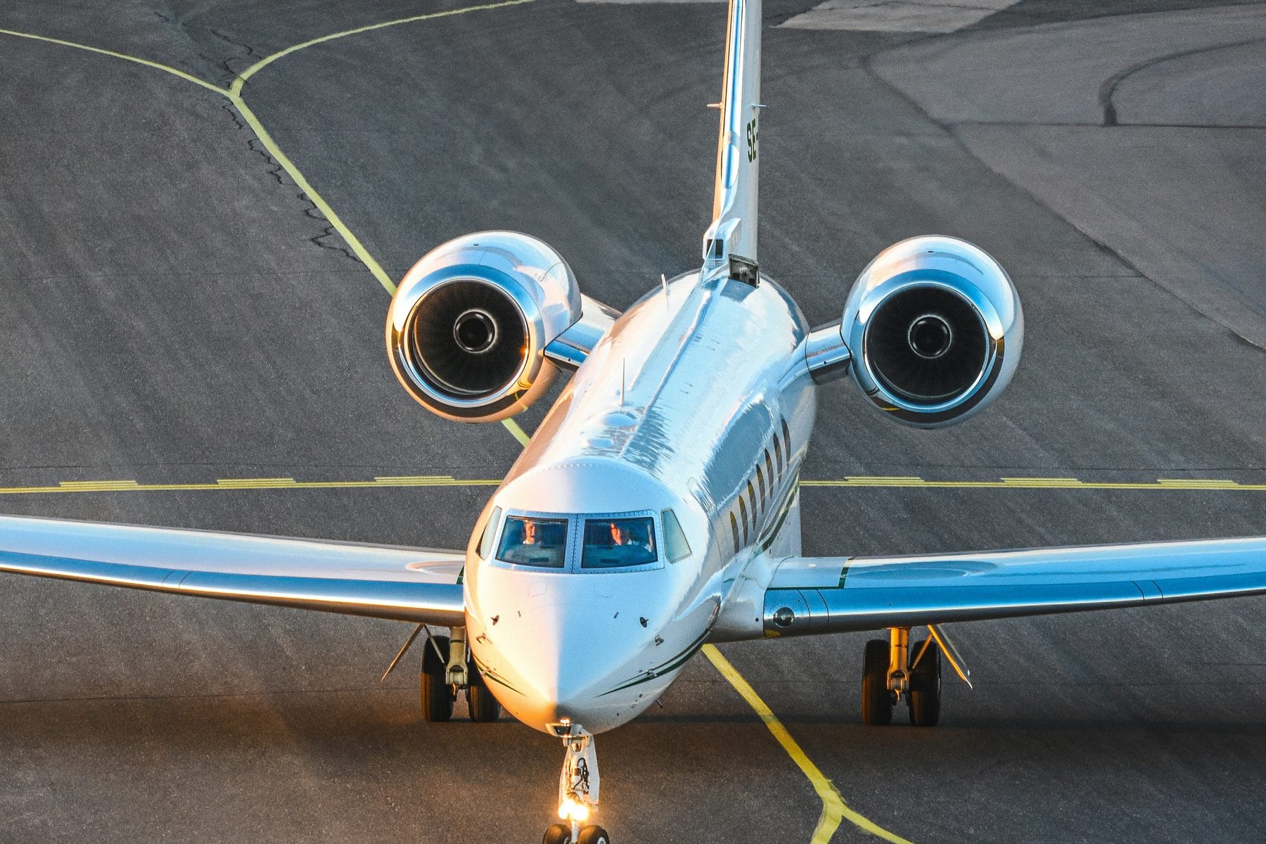 Private jet taxiing head-on at golden hour
