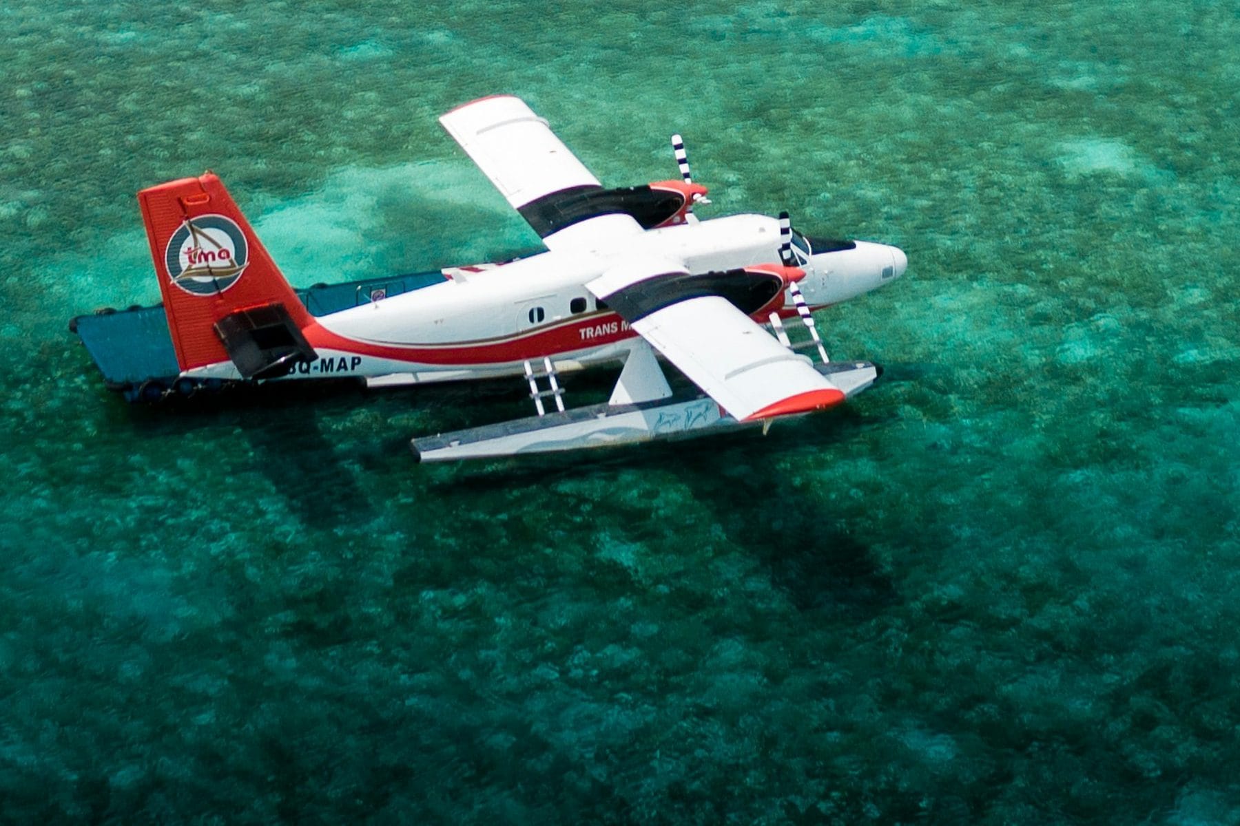 Seaplane resting on a turquoise lagoon, seen from above