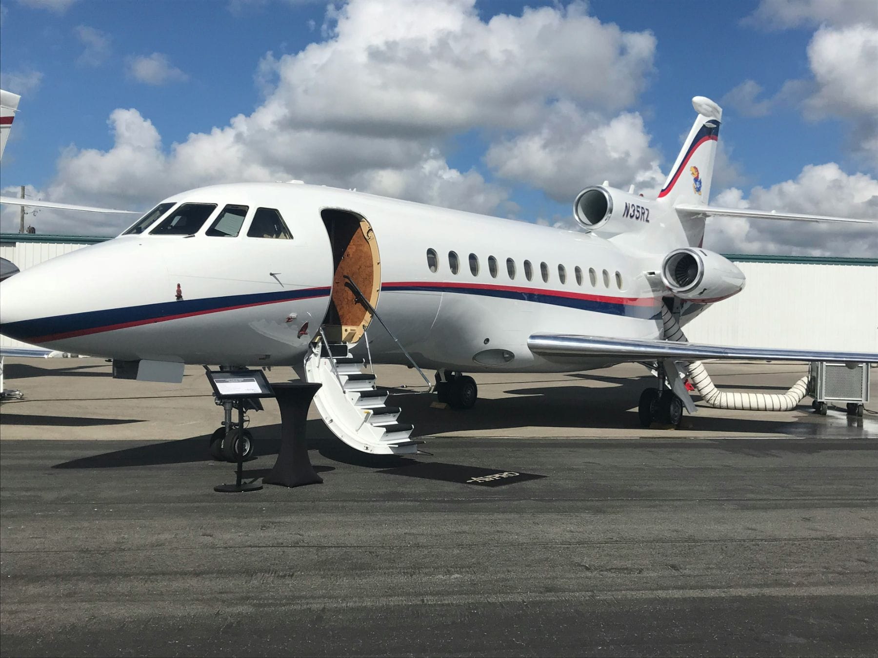 A private jet parked on the ramp with its airstair door open