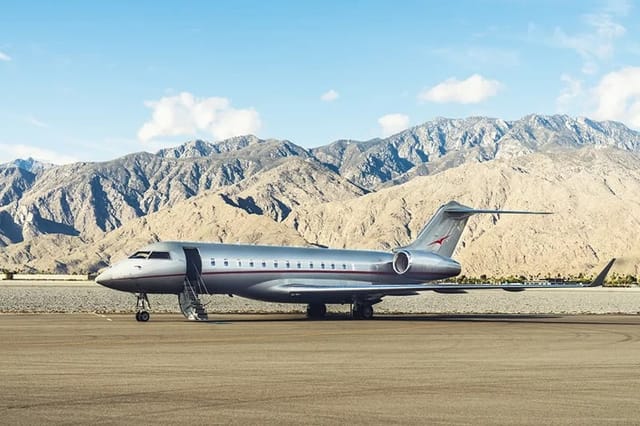 A Bombardier Global parked on the ramp with desert mountains behind it
