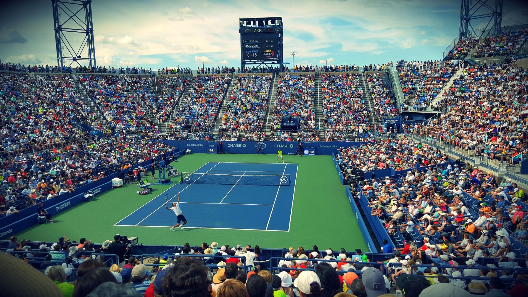 A packed stadium crowd watching a match on a sunny afternoon